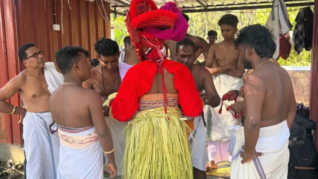 Theyyam performer being dressed in traditional attire before ritual performance in Kannur